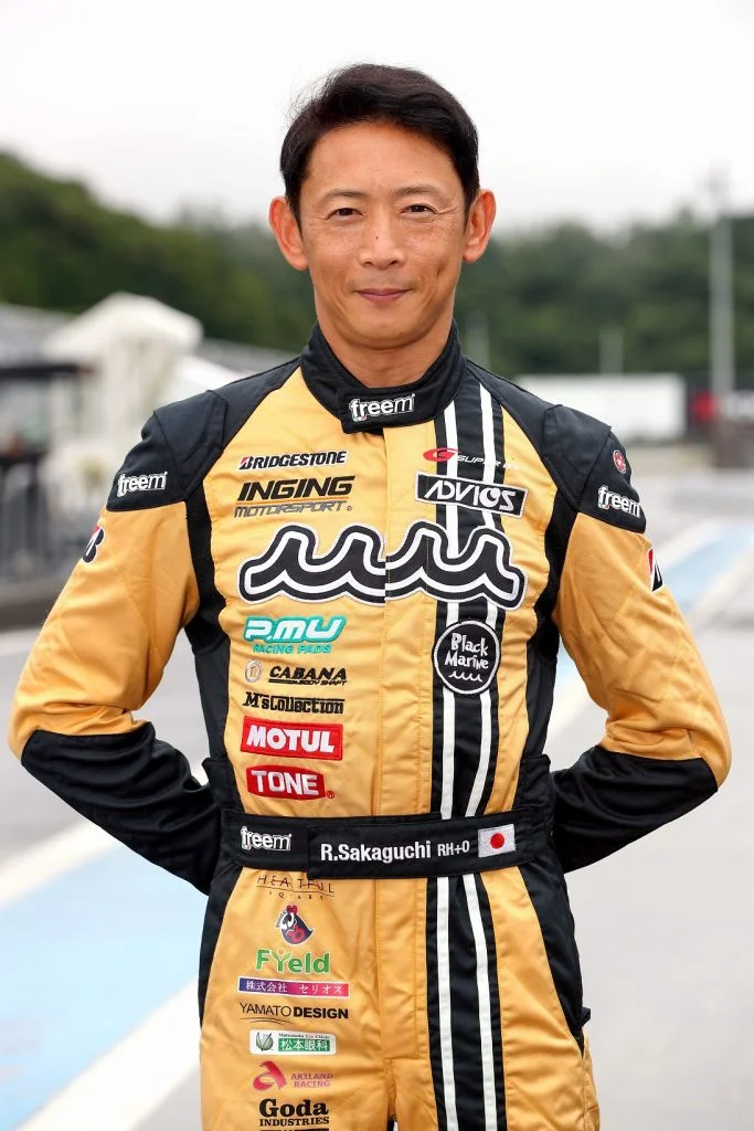 黄色いレーシングスーツを着たドライバーのポートレート写真