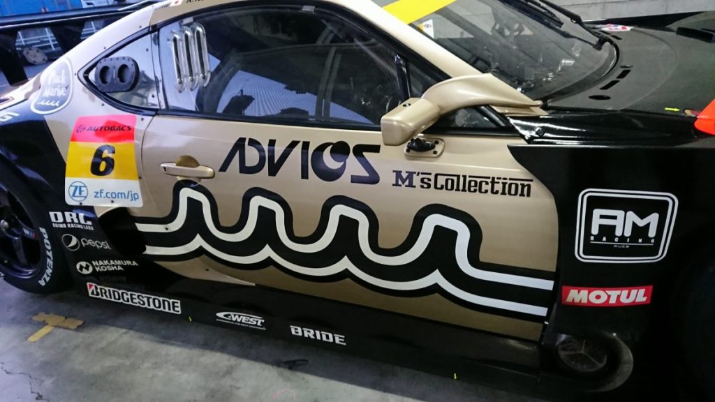 ADVICS muta Racing INGING M's Collectionロゴ ガレージ内ドアパネルクローズアップ