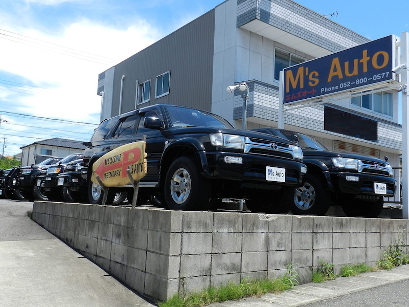 M'sオートの店舗前に並んだ複数の黒いハイラックスサーフを撮影した外観写真