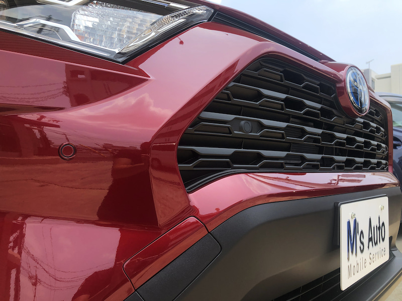 赤いRAV4のフロントグリルとヘッドライトをアップで撮影した写真