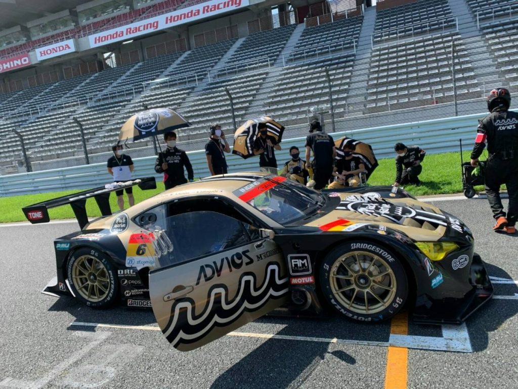サーキットのピットでM'sコレクション協賛のスーパーGT参戦車両を横から撮影した写真