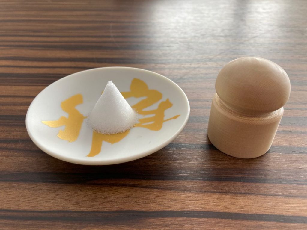 小皿に盛った塩の山と木製容器を並べて撮影した写真
