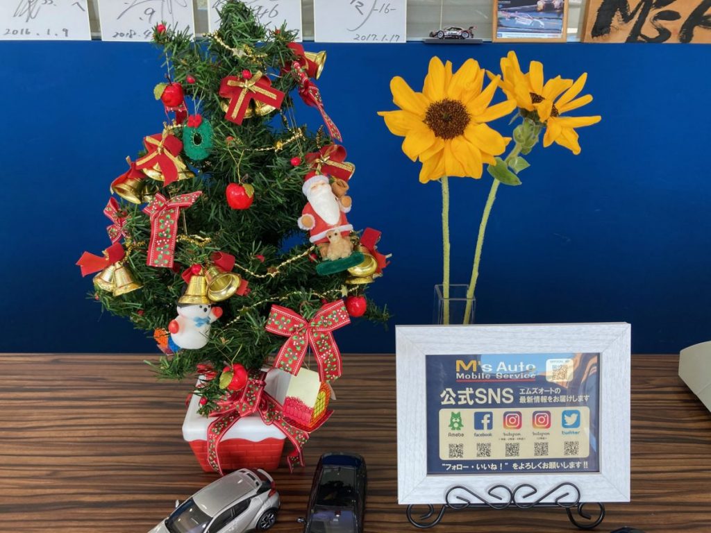 店内カウンターに飾られたミニクリスマスツリーとひまわりの花