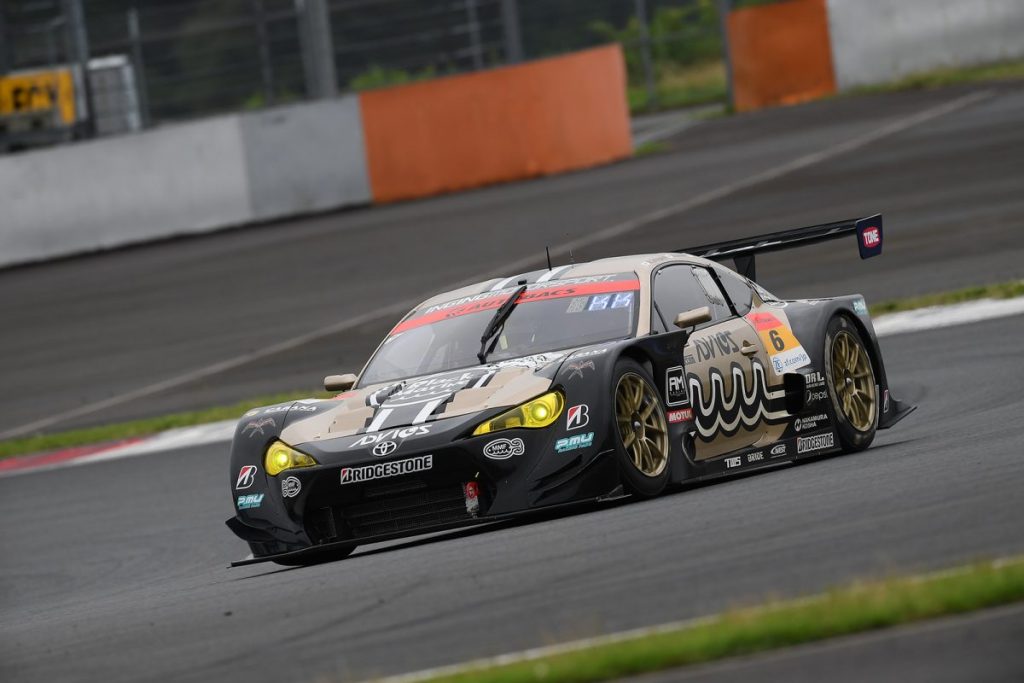 コーナーを走行するレースカーを正面から撮影した写真