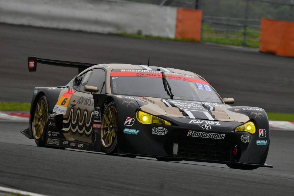 サーキットを走行するレースカーを正面斜めから撮影した写真