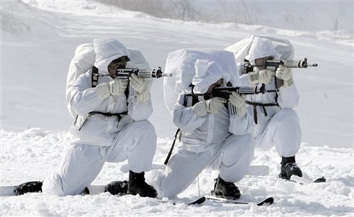 雪原で白い迷彩服を着た兵士3名が銃を構える様子を撮影した写真
