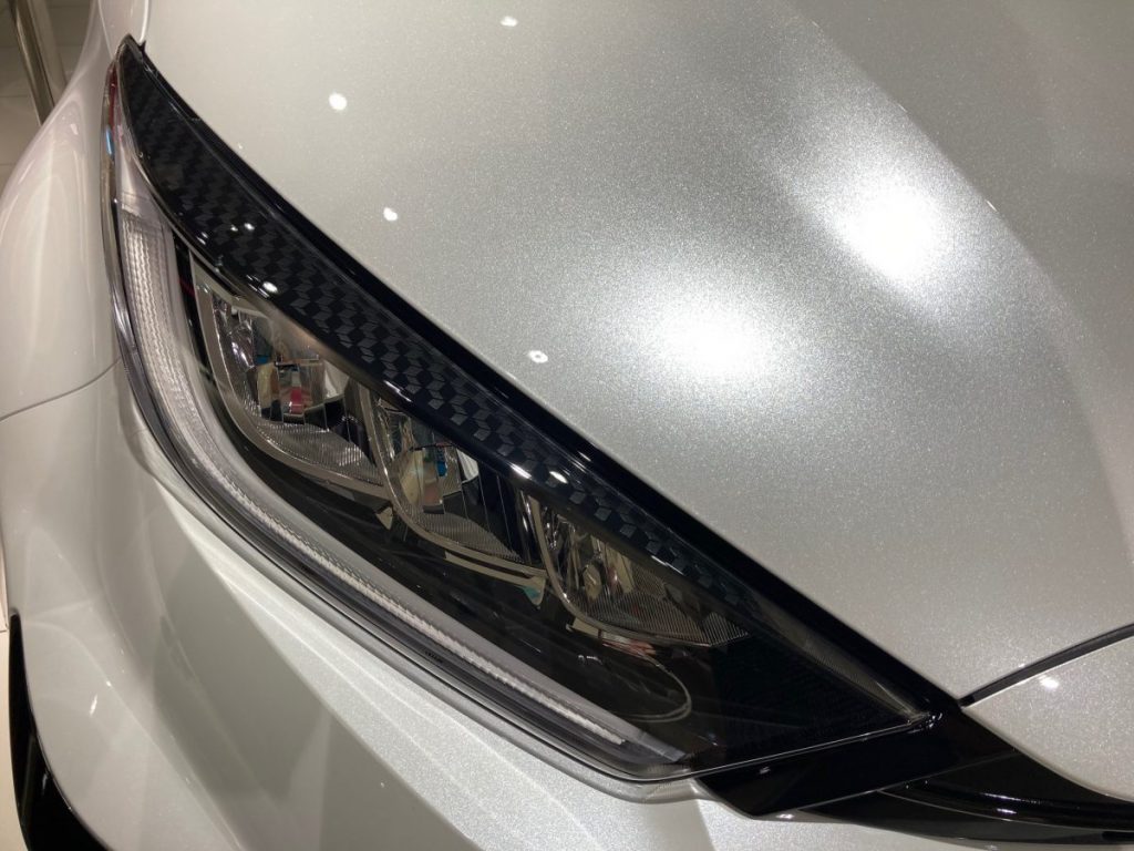 銀色の車のヘッドライト部分を接写した写真
