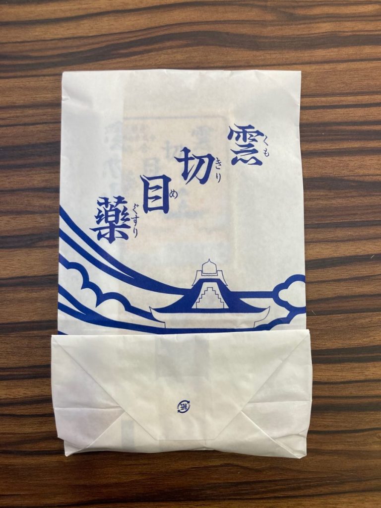 雲切目薬と書かれた白い紙袋を木製テーブルに置いた写真