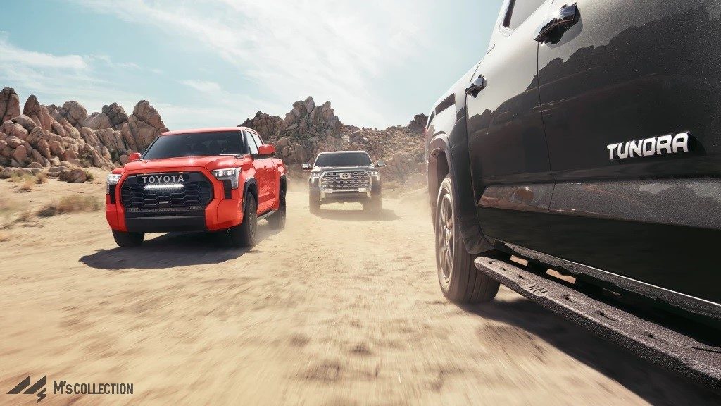 レッドとブラックの2台のTUNDRA TRD-PROが荒野を走行するサイドビュー