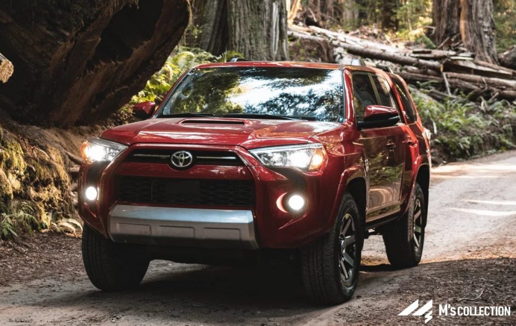 レッドカラーの4RUNNER 森の中の未舗装路を走行するフロント外観