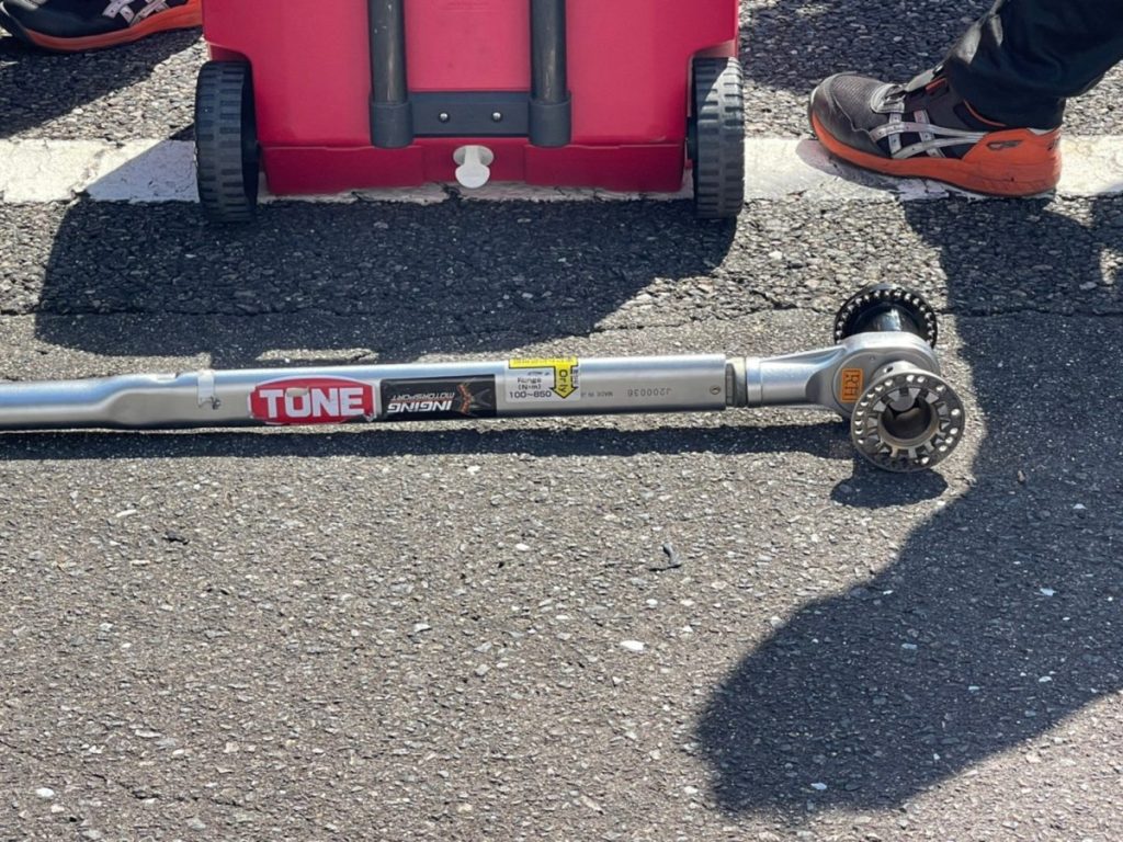 ピット作業で使用されるトルクレンチと工具カート、路上に置かれた整備器具