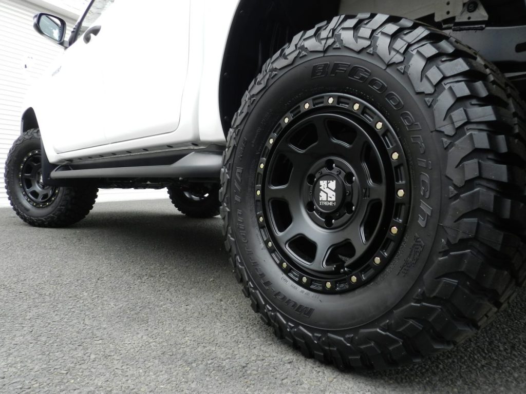 TOYOTA HILUX X GUN125 XJ07黒ホイールとBFグッドリッチマッドテレーンを低アングルでクローズアップ