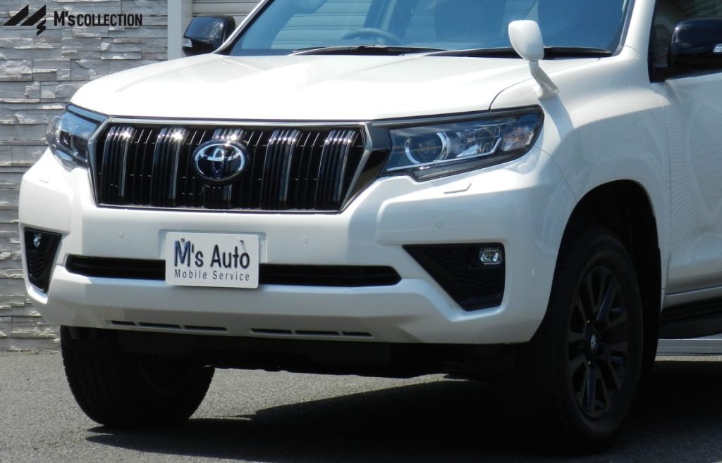 TOYOTA LAND CRUISER PRADO 白 低アングルフロント正面、黒グリルとフロントバンパーを含む外観