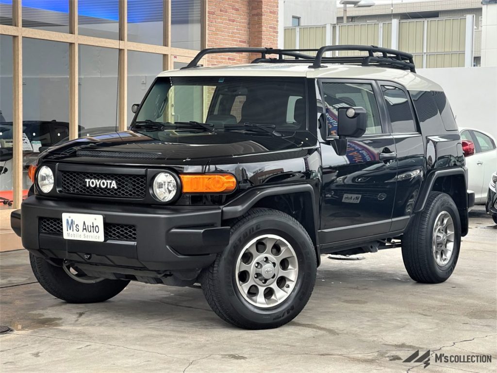 US TOYOTA FJ CRUISER 黒ボディー白ルーフ フロント斜め前方からの外観、ルーフラックと丸いドアミラーが見える様子
