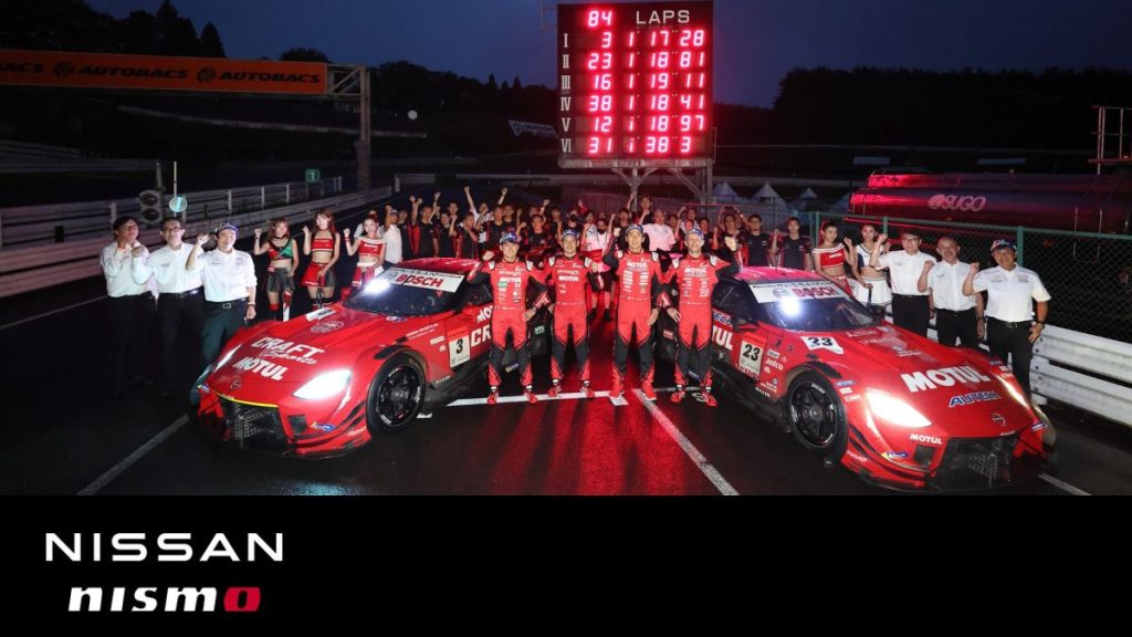 夜のSUGOサーキットでのニスモチーム記念写真、3号車と23号車と全スタッフの集合ショット