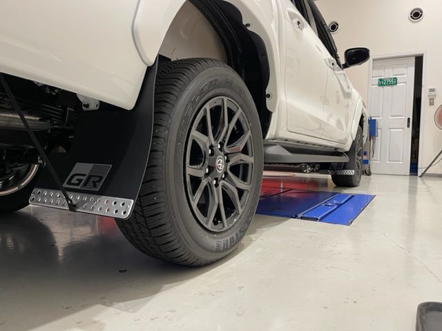 ハイラックスZ GR(GUN125) GRロゴ入りマッドフラップ取付後のホイール周りクローズアップ