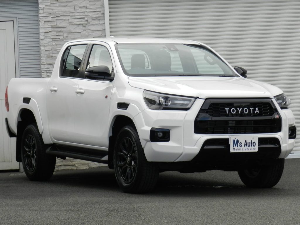 トヨタ ハイラックス GRスポーツ ホワイト 屋外駐車場でのフロント左方外観