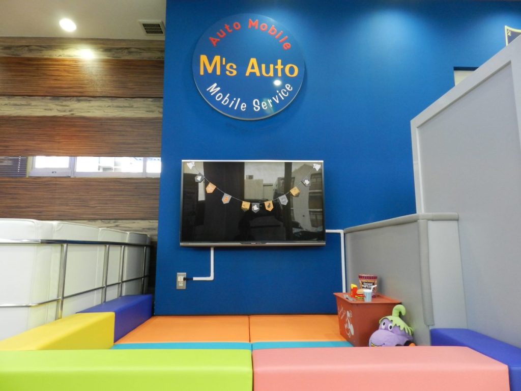 エムズオート店内 M's Auto看板とガーランド飾りのキッズスペース